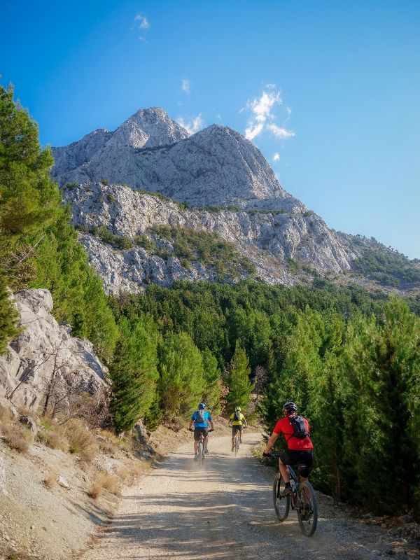 Three cyclists biking on gravel road on Biokovo