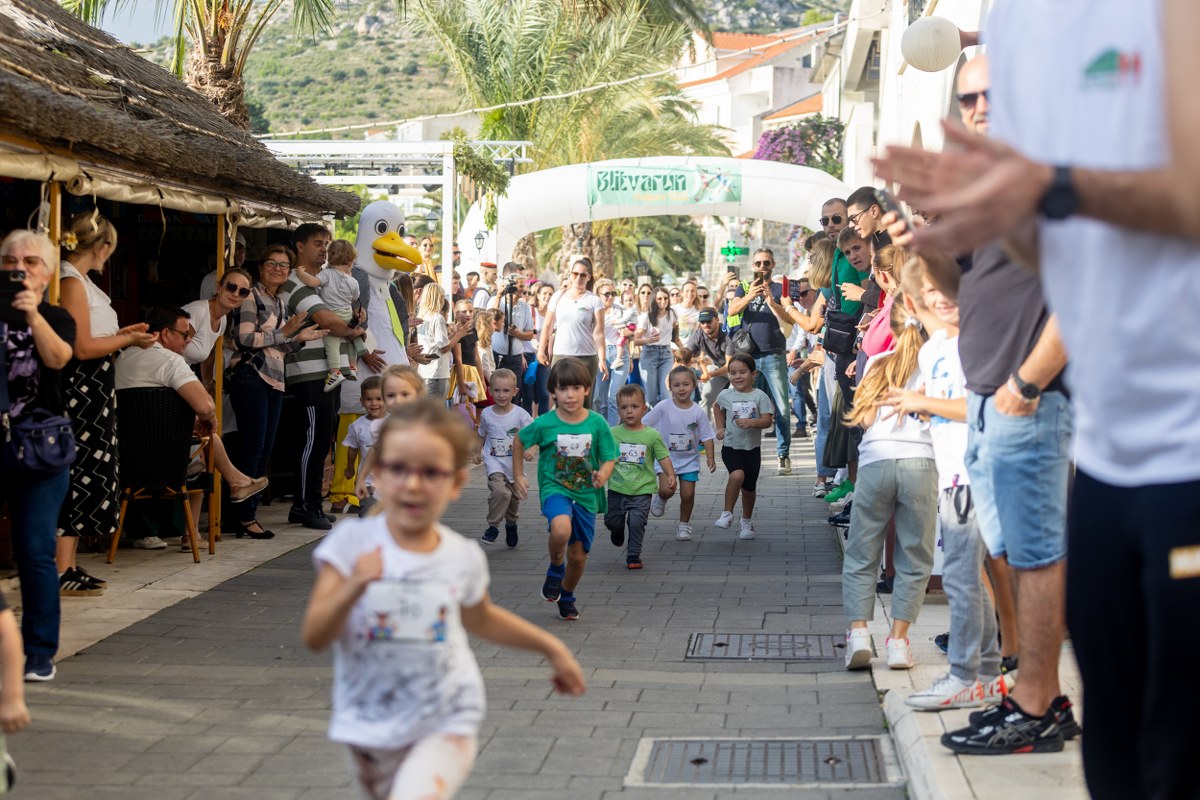 Kids running through a street during the Blitvijada festival and the blitvarun race
