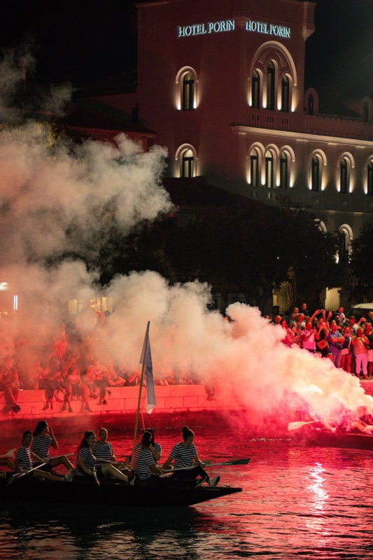 Boat with red smoke flares on the water at night