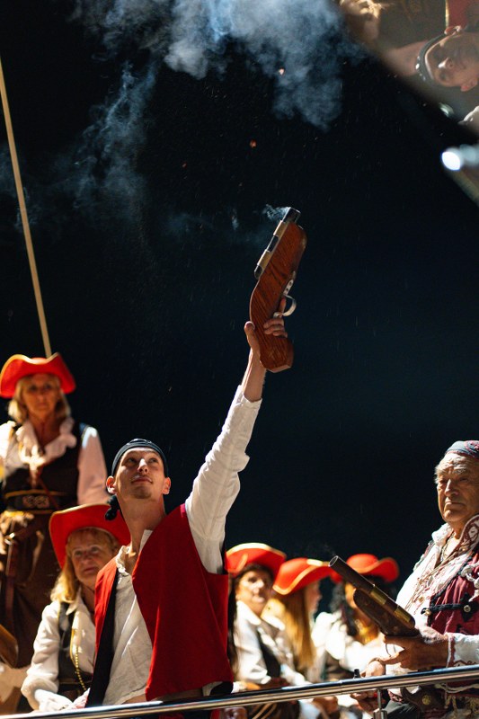 Group of people in costume holding a gun at a night event