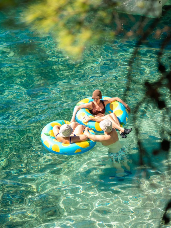 Three women relaxing on an inflatable ring in turquoise sea durning bablje lito