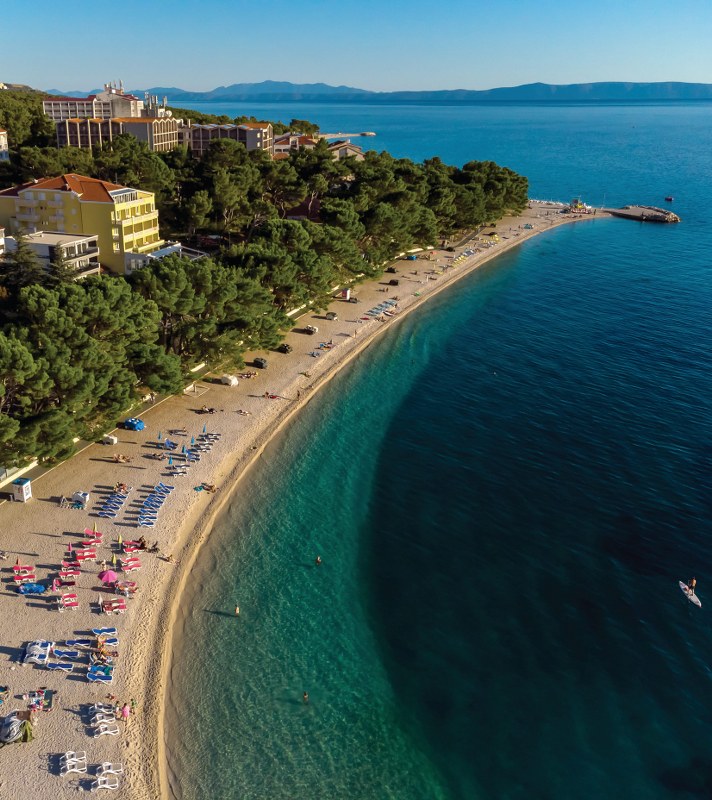 Pogled iz zraka na plažu Nikolina u zalazak sunca u Baškoj Vodi Makarska rivijera